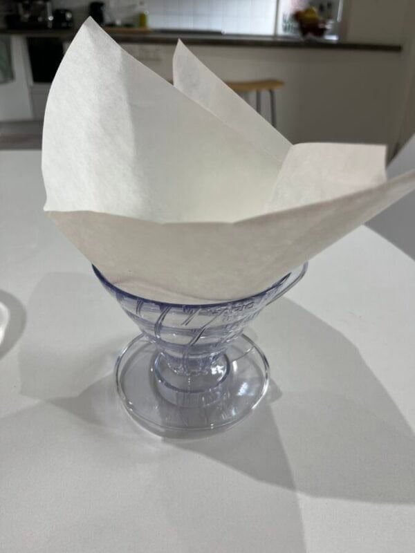 A paper napkin folded into a paper boat sitting on a table