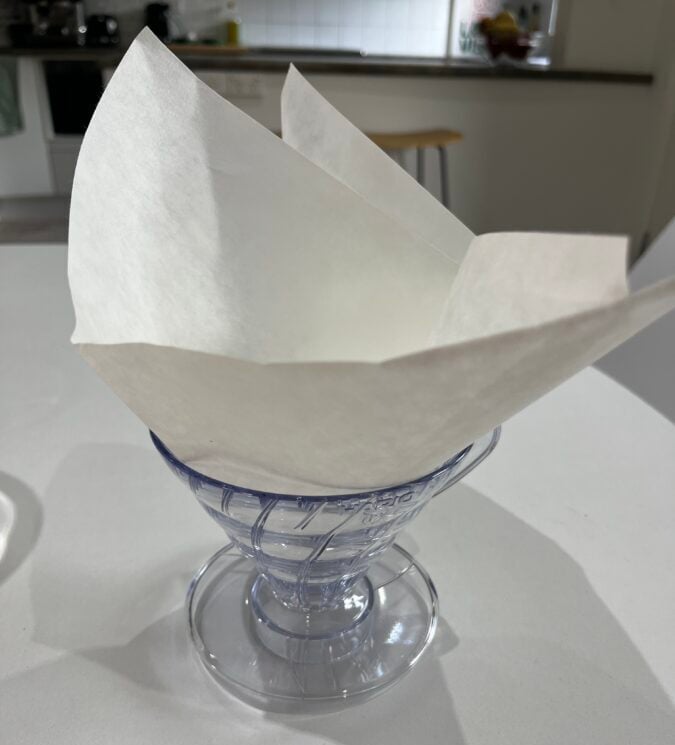 A paper napkin folded into a paper boat sitting on a table